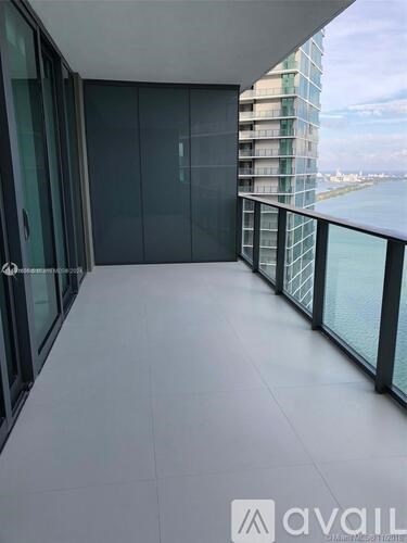 A balcony with glass doors and a view of a building across the way.