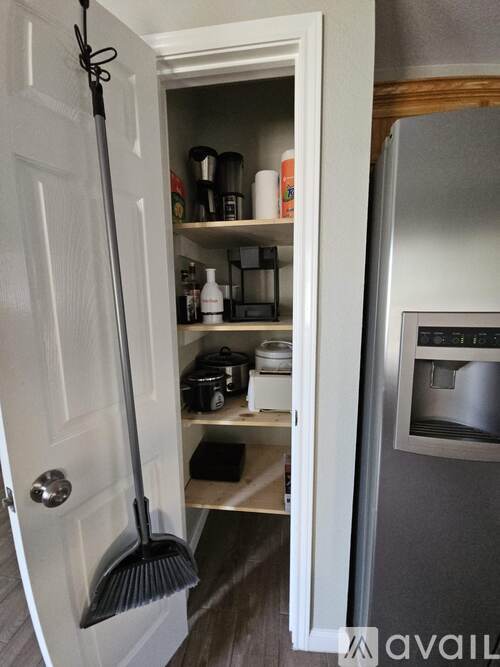 A broom is leaning against a white door.