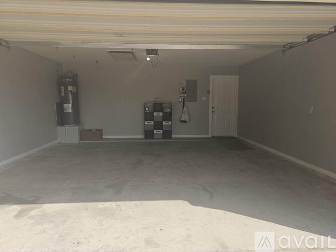 A spacious garage with a white ceiling and a fire extinguisher on the left side.