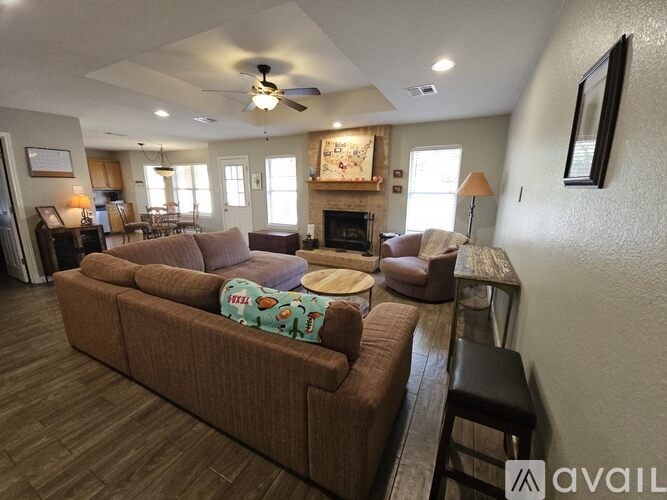 A living room with a brown couch and a fireplace.