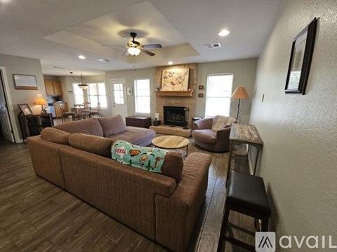 A living room with a brown couch and a fireplace.