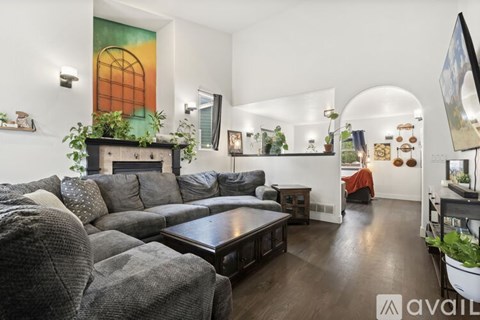 A living room with a grey couch and a wooden coffee table.