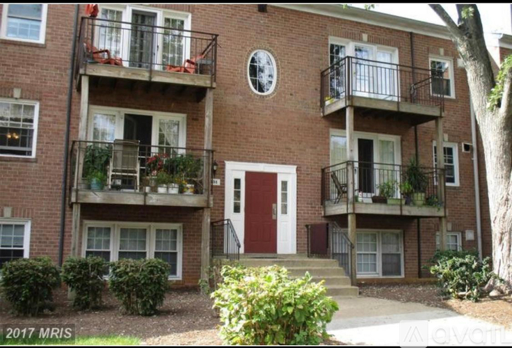 A red brick building with a white door and windows.