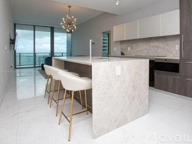 A modern kitchen with a bar area and a view of the sky.