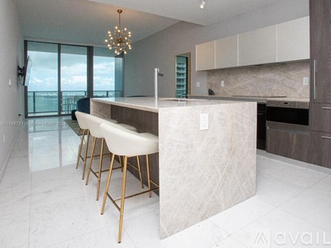 A modern kitchen with a bar area and a view of the sky.