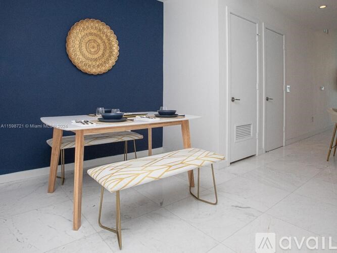 A room with a blue wall and a wooden table with a bench in front of it.