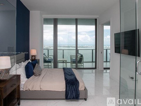 A bedroom with a large bed and a view of the city.