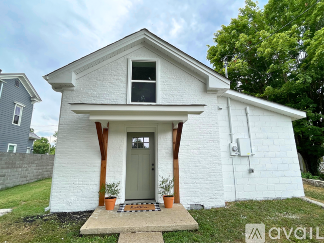 A small white house with a grey door and windows.