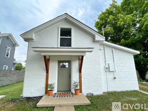 A small white house with a grey door and windows.