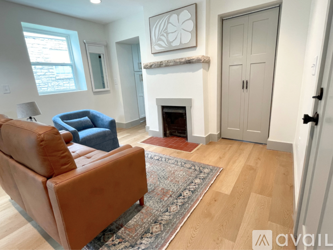 A living room with a brown couch and a fireplace.