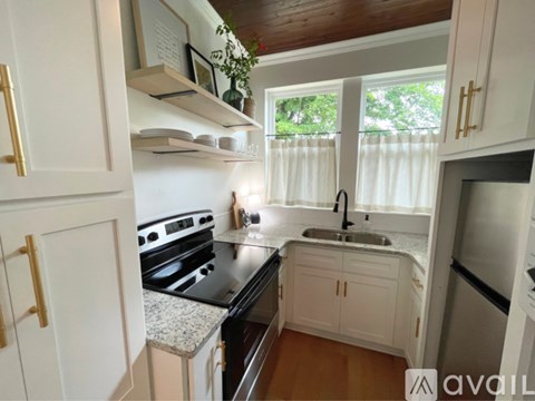 A kitchen with white cabinets and a black stove top oven.