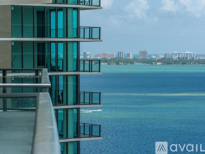 A modern building with glass windows overlooks a body of water.