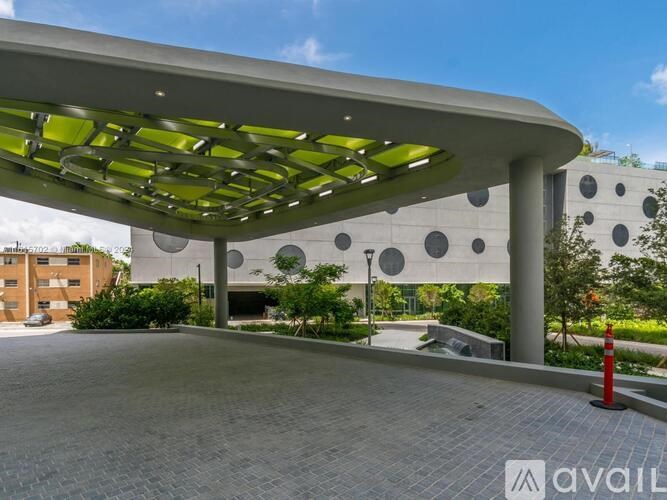 A modern building entrance with a curved roof and circular windows.