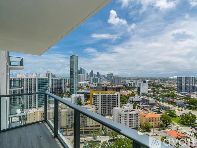 A balcony overlooks a cityscape with various buildings and skyscrapers.