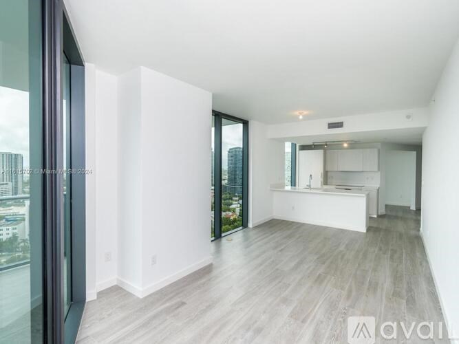 A spacious, empty room with a large window and a sliding glass door.