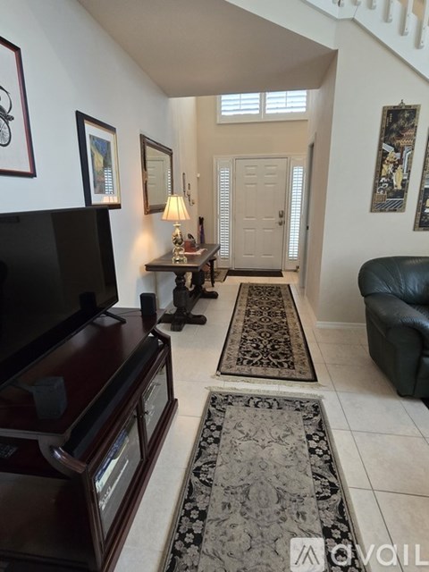 A living room with a black couch and a television.