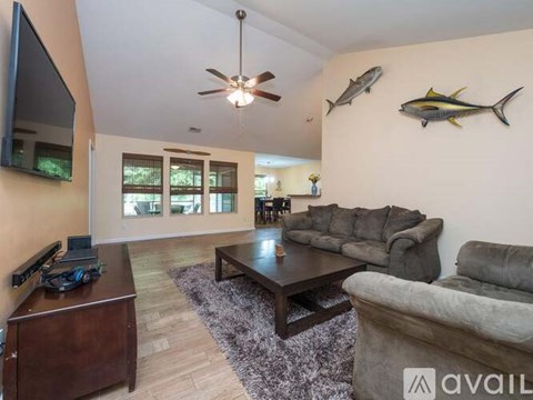 A living room with a brown coffee table and grey couch.