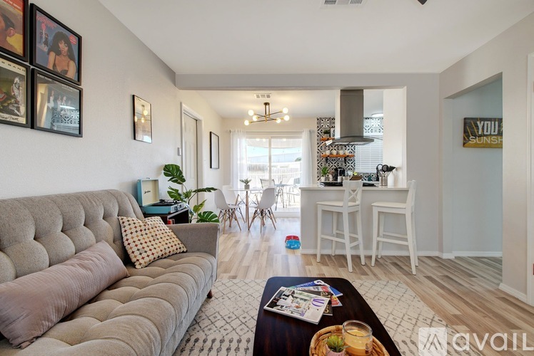 A living room with a grey couch and a coffee table with magazines on it.