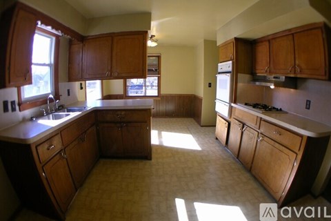 A kitchen with wooden cabinets and a large island.