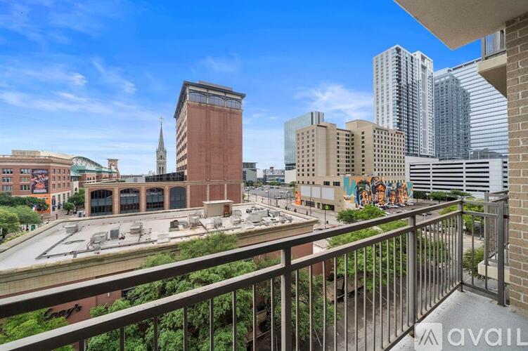 A balcony overlooks a city street with a mix of modern and older buildings.