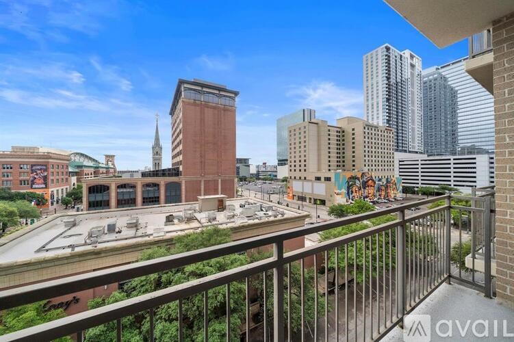 A balcony overlooks a city street with a mix of modern and older buildings.