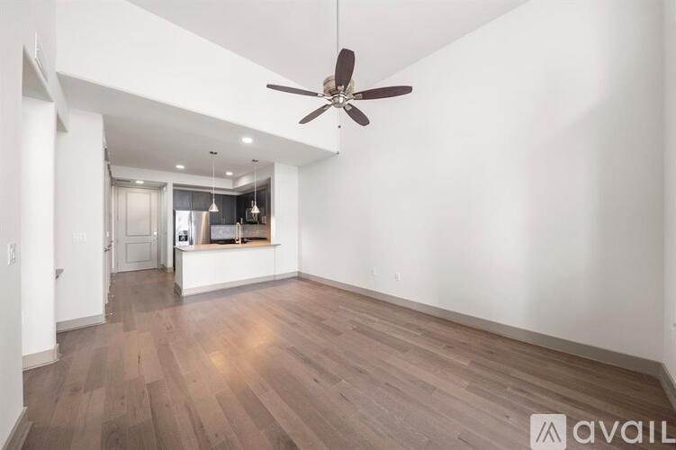 A room with a ceiling fan and wooden flooring.
