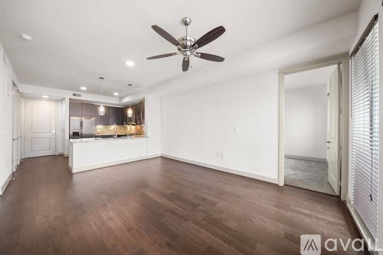 A spacious room with a ceiling fan and wooden flooring.