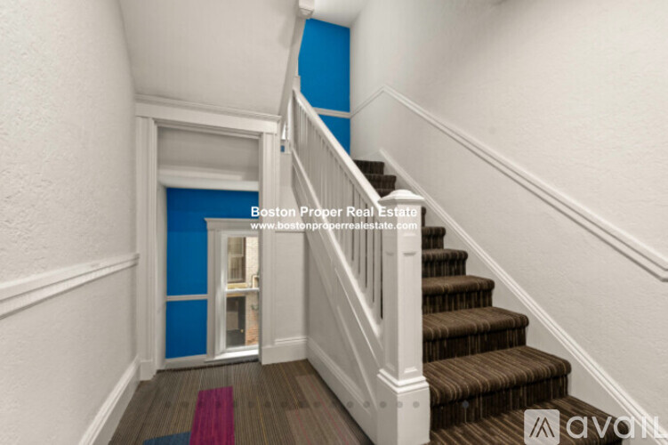 A staircase with a blue wall at the top.