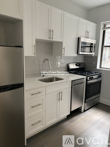 A kitchen with white cabinets and stainless steel appliances.
