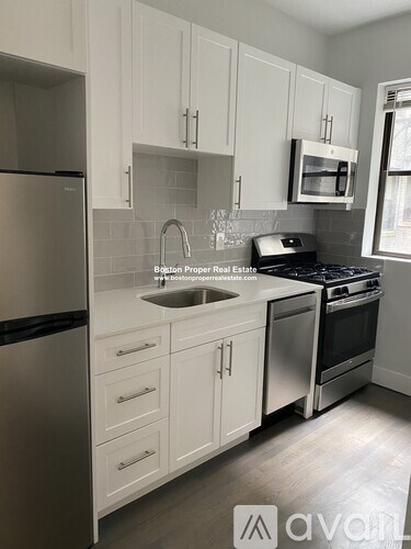A kitchen with white cabinets and stainless steel appliances.