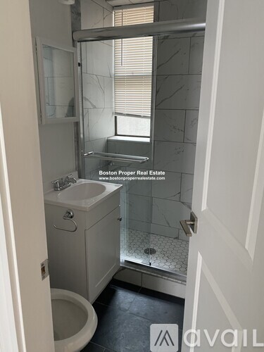 A bathroom with a toilet, sink, and shower.