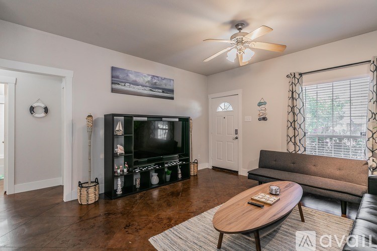A living room with a television, a couch, and a coffee table.