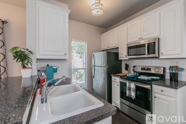 A kitchen with white cabinets and a granite countertop.