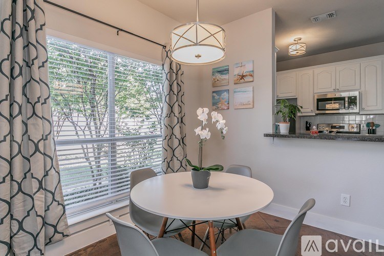 A dining room with a table, chairs, and a plant.