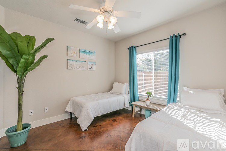 A bedroom with two beds and a ceiling fan.