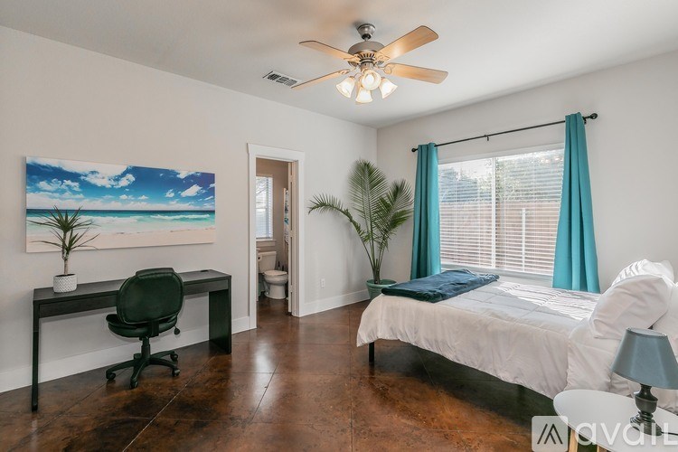 A bedroom with a bed, desk, and chair.