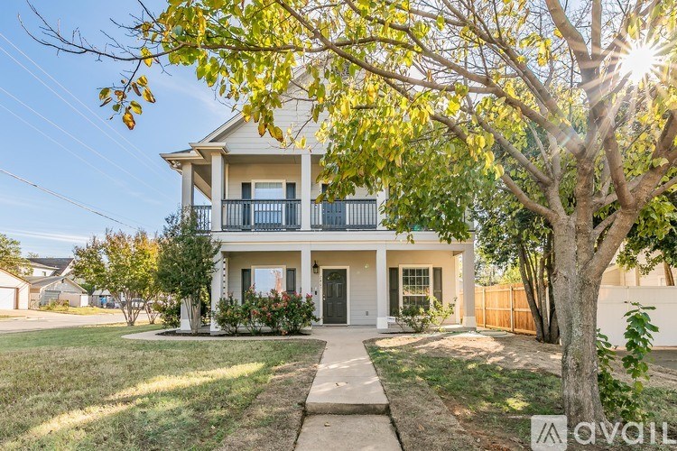 A house with a tree in front of it is for sale.