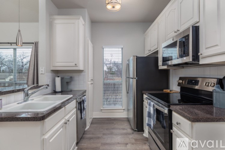 A kitchen with white cabinets and black appliances.
