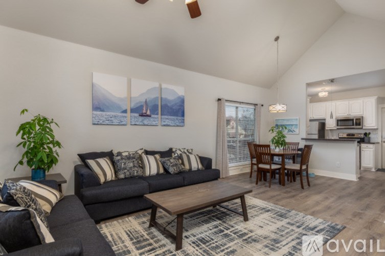 A living room with a couch, a coffee table, and a dining table.