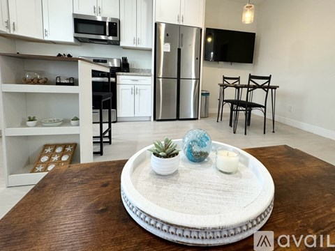 A modern kitchen with a wooden table in the foreground.