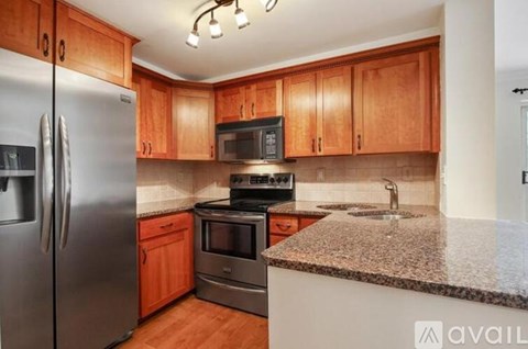 A kitchen with wooden cabinets and granite countertops.