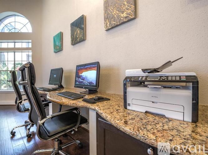 A home office with a desk, chairs, and a printer.