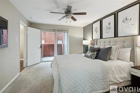 A bedroom with a large bed and a ceiling fan.