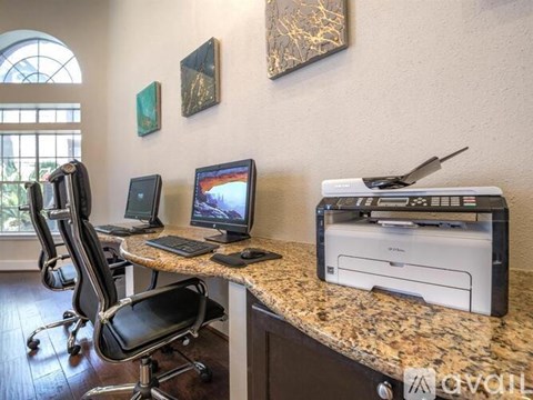 A home office with a desk, chairs, and a printer.