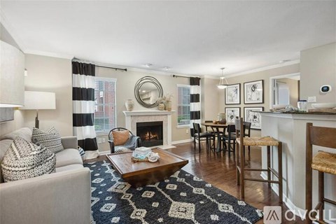 A living room with a fireplace and a dining table.
