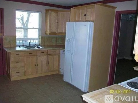 A kitchen with wooden cabinets and a white refrigerator.