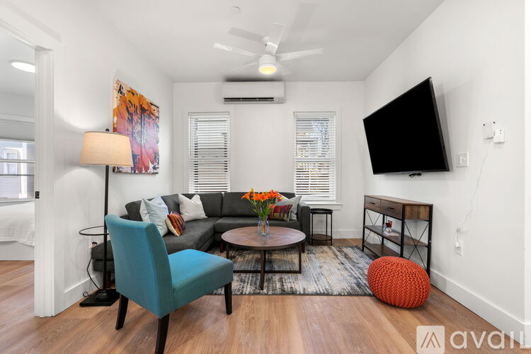 A living room with a blue chair and a black TV.