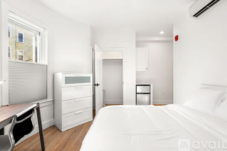 A bedroom with a bed, desk, and chair.