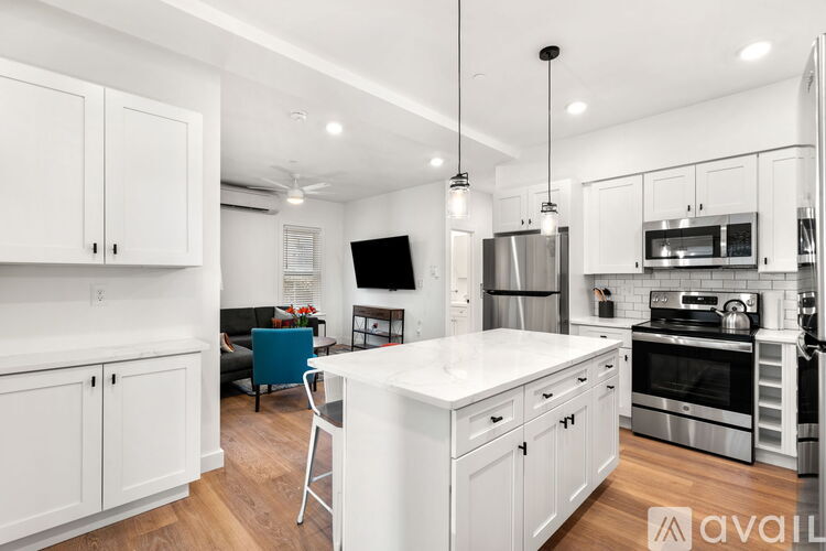 A modern kitchen with white cabinets and a large island.