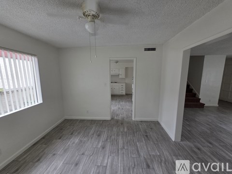 A room with a ceiling fan and a window with blinds.
